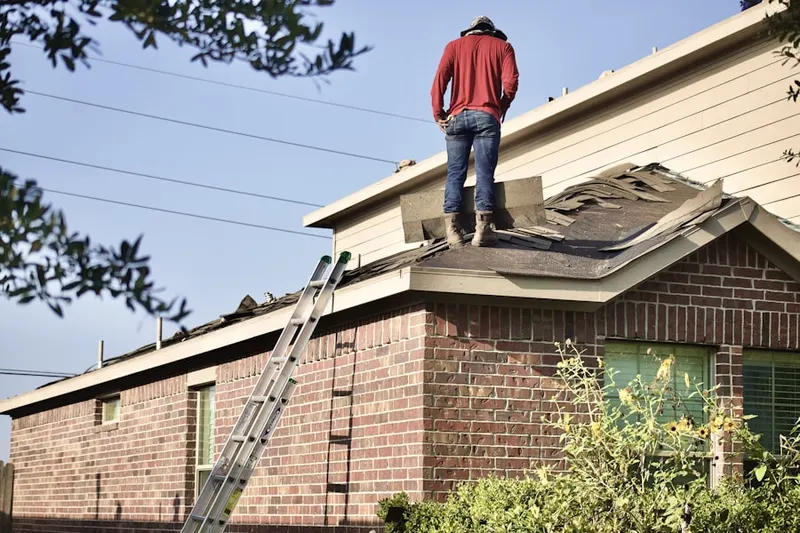 Professional roofer working on a residential roof in Upton